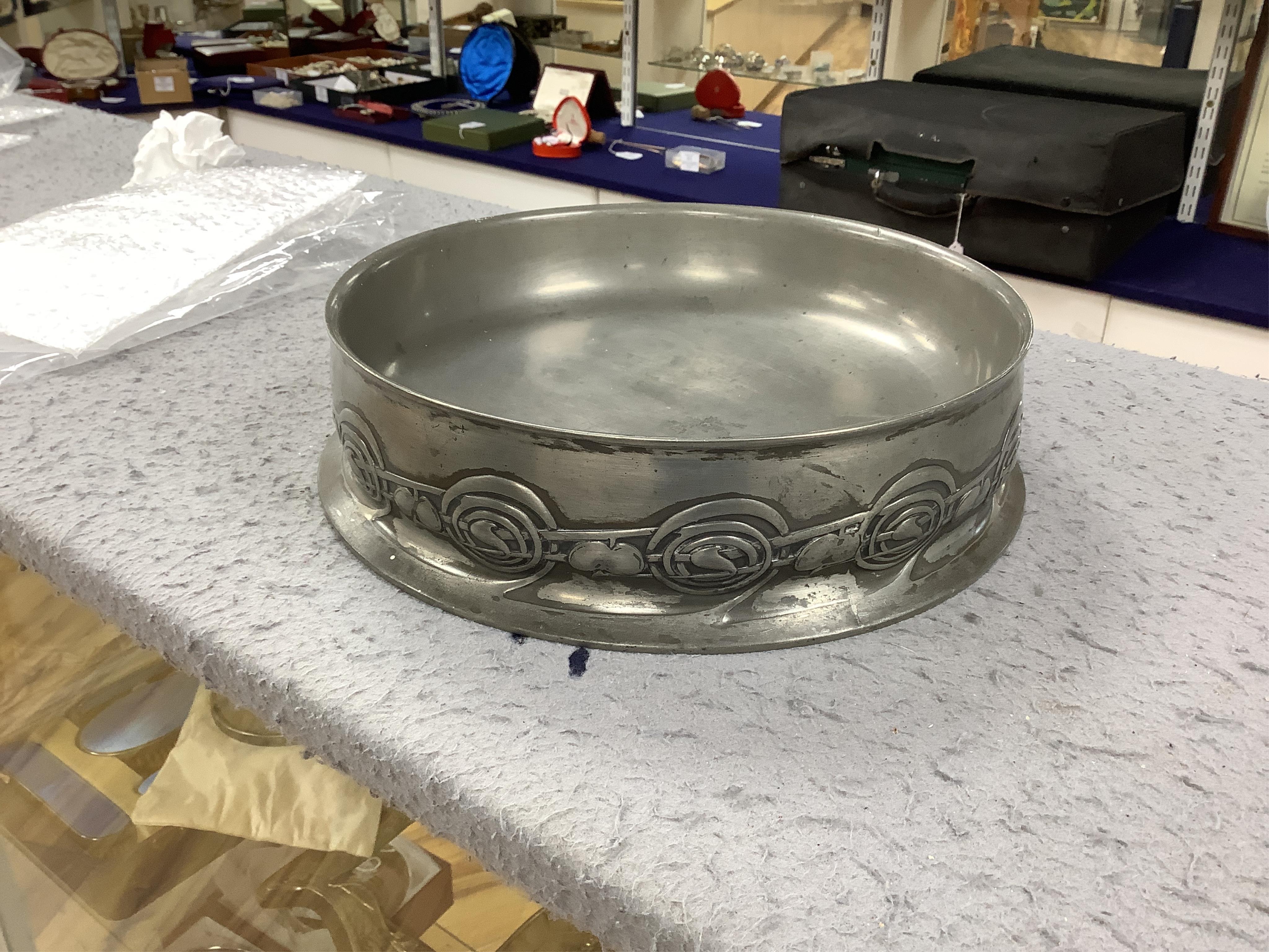 Seven items of pewter, including a Liberty Tudric tray, 45.5cm width, an Archibald Knox jug, a large Tudric bowl, 27cm diameter, a dish with glass liner, another dish and two paper knifes